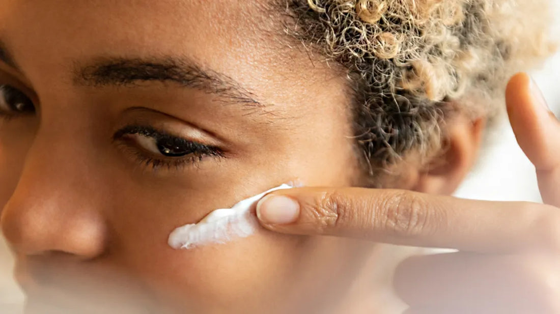 young lady applying cream to her face